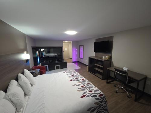 a hotel room with a large bed and a desk at Red Roof Inn Sutton in Sutton