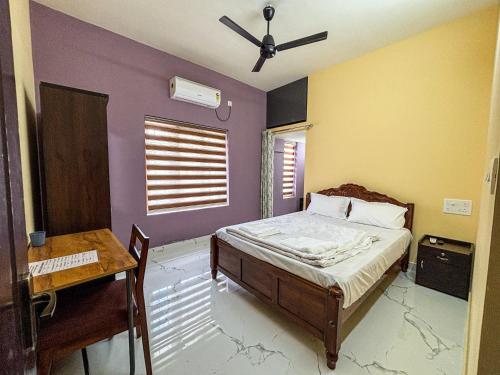a bedroom with a bed and a ceiling fan at Kattuvallil AGAPE Homestay 4B2HK in Thiruvalla