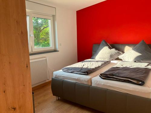 a bed in a room with a red wall at Ferienhaus Louis Philippe in Altlay