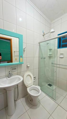 a bathroom with a toilet and a sink and a shower at Villa Sempre Viva in São João Batista do Glória