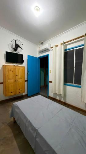 a bedroom with a large bed and a blue door at Villa Sempre Viva in São João Batista do Glória