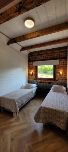 a large room with two beds and a window at Z Górki Na Pazurki in Polańczyk