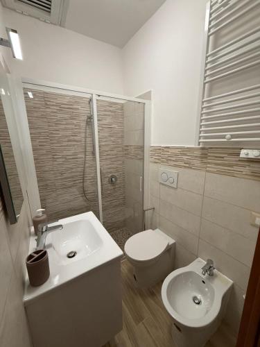 a white bathroom with a toilet and a sink at Vale house in Monte San Biagio