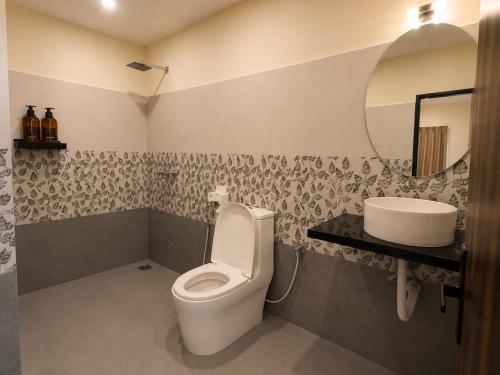 a bathroom with a toilet and a sink at Coco Nest Mandrem in Mandrem