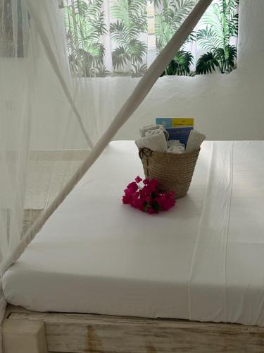 a white mattress with a basket of flowers on it at airaMIudi in Watamu