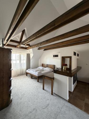 a large room with a bed and a table at Penzión SIMI in Tatranská Lomnica