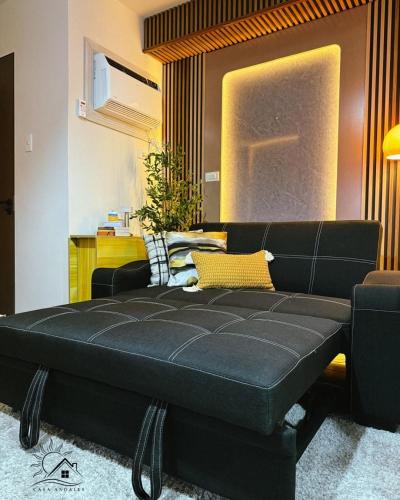 a black bed in a room with a couch at Modern Japandi Studio with Pool Near Mactan Airport in Bankal