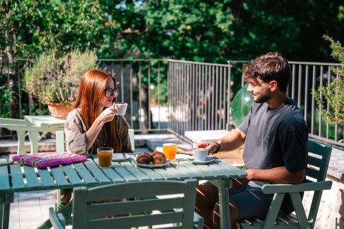 a man and a woman sitting at a picnic table at Borgo Majella by Rentbeat in Abbateggio