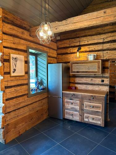 a kitchen with wooden walls and a window and a chandelier at Kachlówka in Lachowice