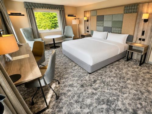 a hotel room with a bed and a desk and chairs at Cabarfeidh Hotel in Stornoway