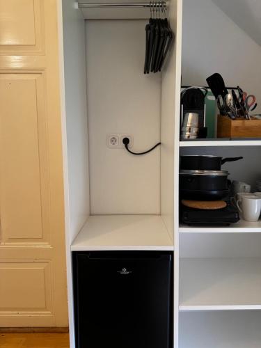 a kitchen with a black and white refrigerator at Jade Villa an der Nordsee in Jaderaltendeich