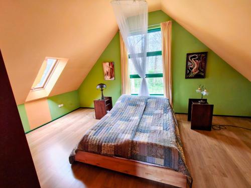 a bedroom with a bed in a room with green walls at Haus 9 am Fluss in Witnica