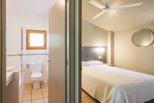 a bedroom with a bed and a toilet and a sink at El Corral in Lladurs