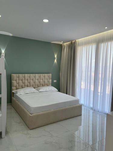 a bedroom with a large bed and a large window at Break Room Dea in Draç