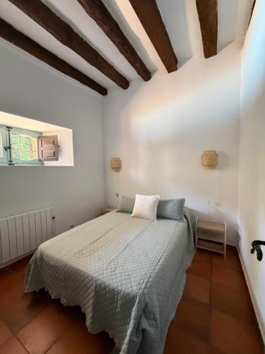 a bedroom with a bed in a white room at La Casuca in Riaza