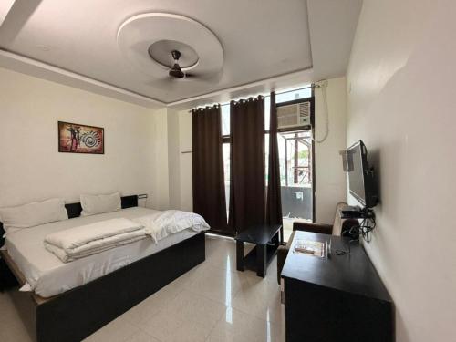 a bedroom with a bed and a desk and a television at Hotel A3cube in Panna