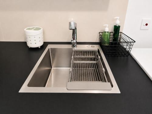 a kitchen sink with a dish drying rack next to it at Beachfront Sky Studio with Ocean View in Wattala