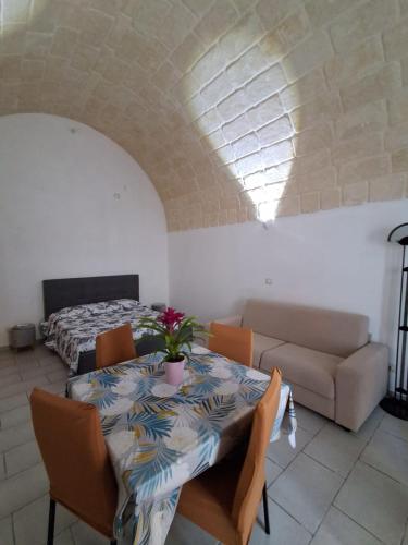 a room with a table and a couch and a bed at Il Carrubo in Massafra