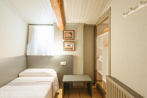 a small bedroom with two beds and a table at El Corral in Lladurs