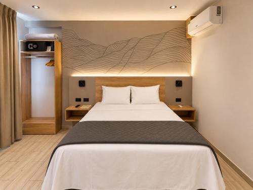 ein Schlafzimmer mit einem Bett und einer Wand mit einem Wandbild in der Unterkunft Senoma Hotel - Adults only in Ica