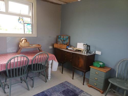 a dining room with a table and chairs and a desk at Tiny living on the Wild Atlantic Way in Tralee