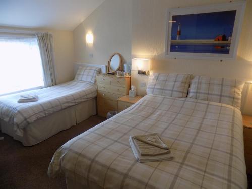 una camera d'albergo con due letti e uno specchio di Belle View a Skegness