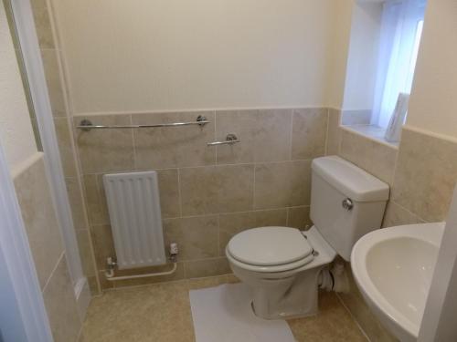 a bathroom with a toilet and a sink at Belle View in Skegness
