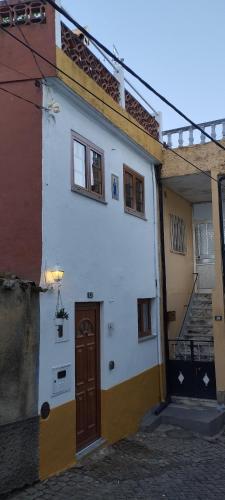 a white building with a brown door and windows at Casa Rústica da Lavandeira in Valongo dos Azeites