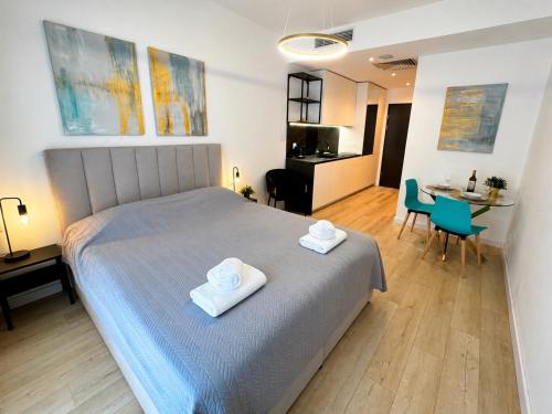 a bedroom with a bed with two towels on it at Poznań Plac Wolności 6 Bond in Poznań