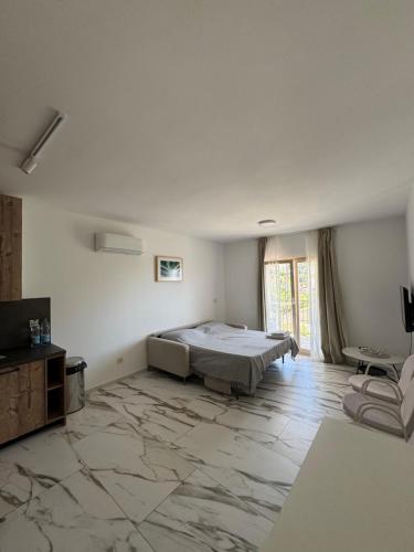 a bedroom with a bed and a television in it at MostOliva luxury Rooms in Pržno