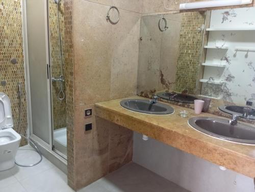 a bathroom with two sinks and a shower at Villa pieds dans l'eau Cabo in Cabo Negro