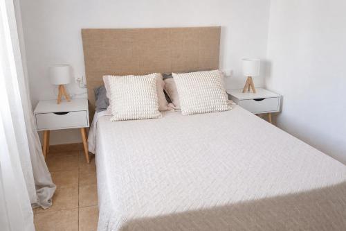 a bedroom with a large bed with two night stands at Formentera Suite 3 in Es Pujols