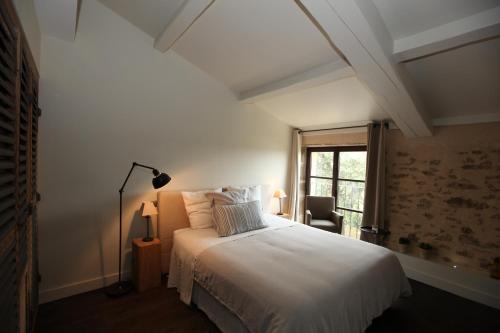 1 dormitorio con cama blanca y ventana en La bergerie de Nano, en Beaumes-de-Venise