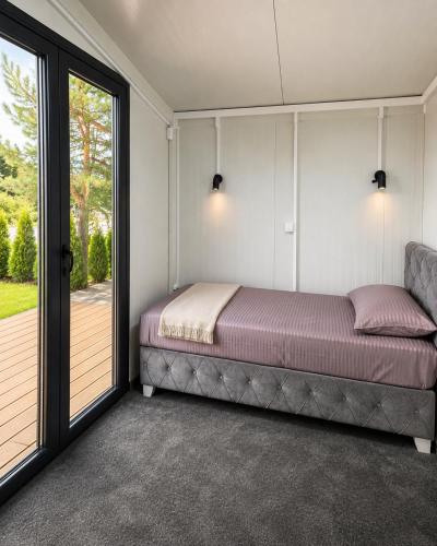 a bedroom with a bed next to a sliding glass door at Oaza mira Zlatibor, Tornik - ENTIRE HOME at Ski Centar Tornik in Tornik