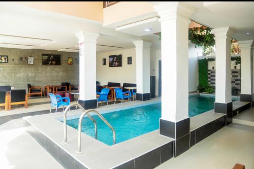 a pool in a hotel with blue chairs and tables at Wiztk suites in Sangotedo