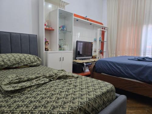 a bedroom with a bed and a tv in it at Evelin Apartment Berat in Berat