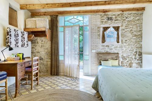 a bedroom with a bed and a desk and a window at Can Portell by 123ole, B&B - Casa Rural in Sant Andreu del Terri