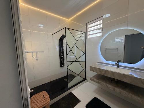 a bathroom with a shower and a sink and a mirror at C-Appart Residence in Tuléar