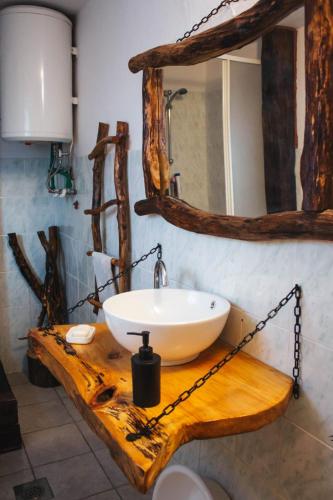 a bathroom with a sink on a wooden table with a mirror at Kuća za odmor San in Lonja