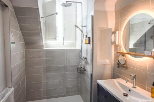 a bathroom with a sink and a shower at Hôtel Le Rohan Charme et Caractère in Pontivy