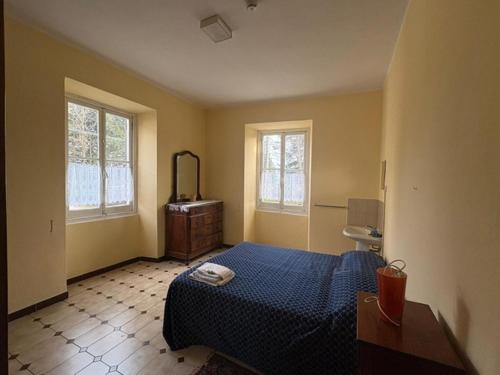 a bedroom with a bed and a dresser and two windows at Govinda in Pontinvrea