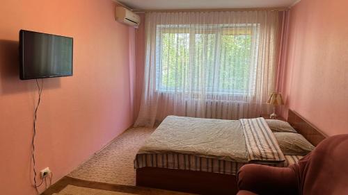 a small bedroom with a bed and a window at Nice Apartment in Kyiv