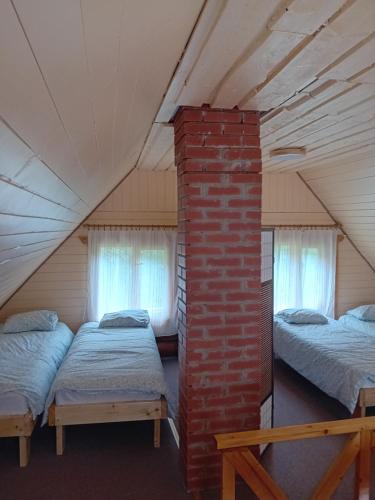 ein Zimmer mit drei Betten im Dachgeschoss in der Unterkunft Pirgu forell in Rapla