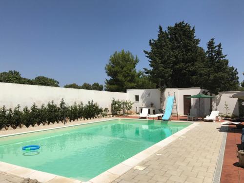 a swimming pool in front of a white building at Botrus Divin Casa in Brindisi
