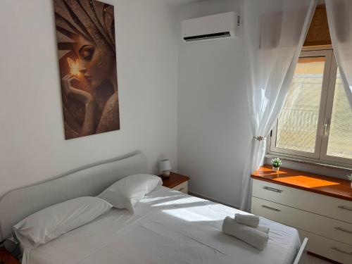 a white bed in a room with a window at DE ROSA'S home 4 in Praia a Mare