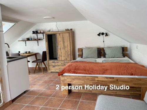 a bedroom with a bed and a kitchen at Murter-Sun Stone House in Murter