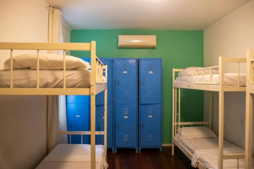 a room with three bunk beds and blue cabinets at Hostel Casa 8 in Rio de Janeiro
