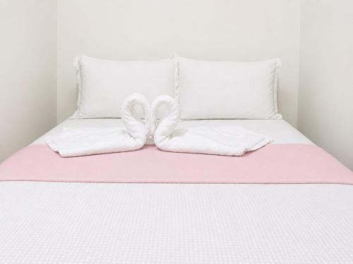 a bed with two white pillows and a pink blanket at Pousada Auroranascerdosol in Manhã
