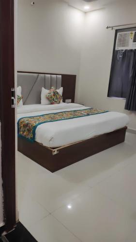 a bed in a white room with at Hotel Grand Taj Pride in Tājganj