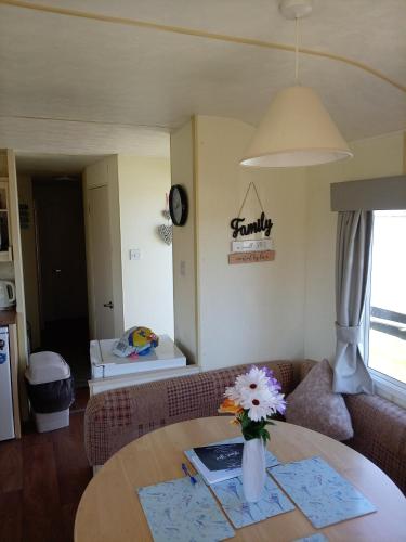 a living room with a table with a vase of flowers at Lucy retreat in Great Driffield